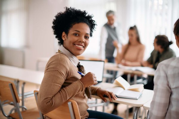 Happy black woman attends class at lecture hall and looks at camera. Happy black woman attends class at lecture hall and looks at camera.